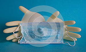 Inflated yellow latex gloves and a blue medical mask on a blue background. photo